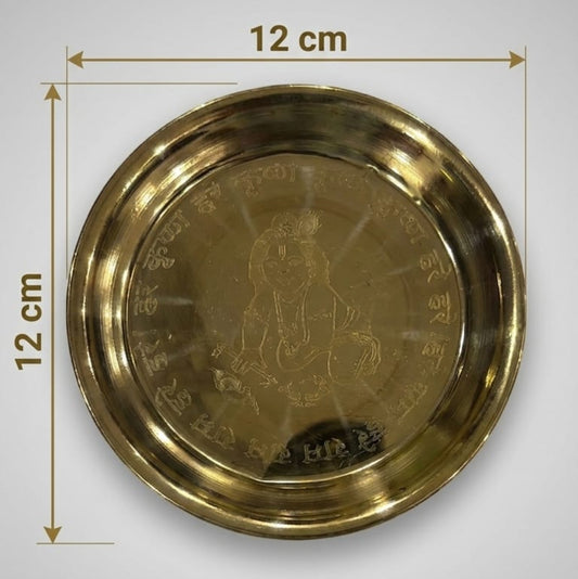 A polished brass Pooja Thali set including a plate, bowl, glass, and decorative spoon