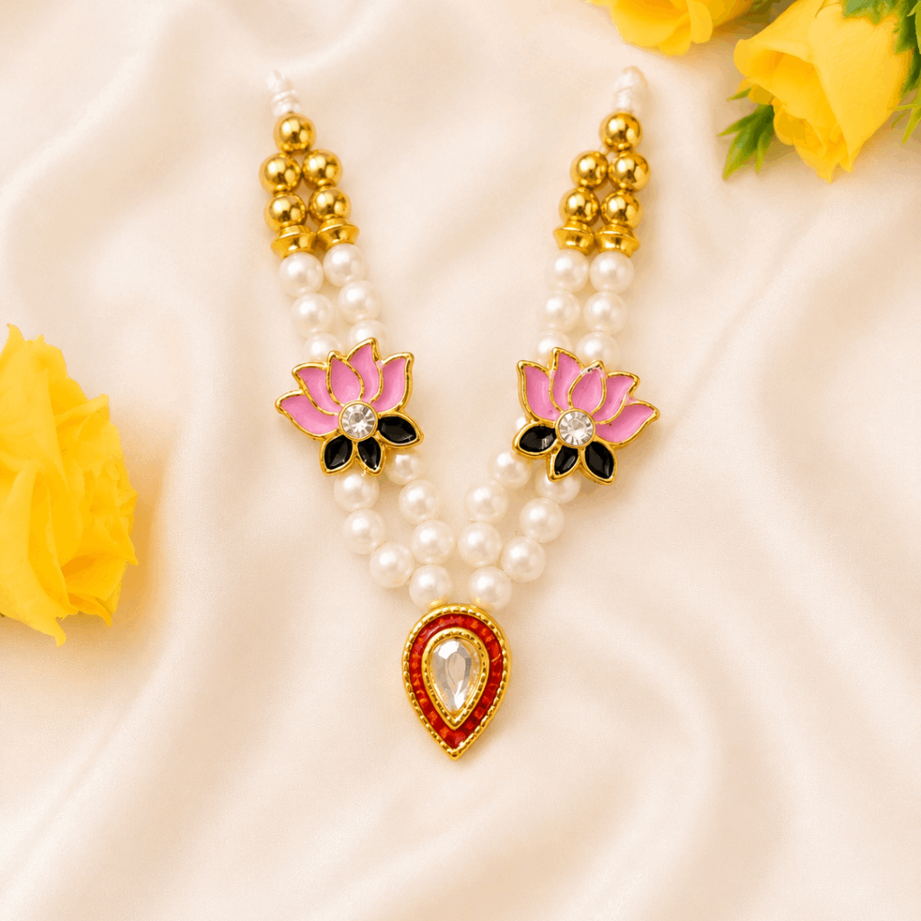 Pearl necklace with pink floral pendants and yellow roses on a beige fabric background