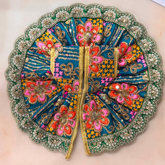 Handcrafted vibrant teal green designer dress and matching crown for Ladoo Gopal Ji, featuring multi-colored thread embroidery and pearl borders.