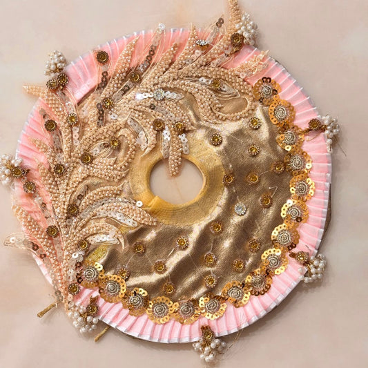 Handcrafted champagne gold and soft pink designer dress and matching crown for Ladoo Gopal Ji, featuring metallic embroidery and pearl detailing.
