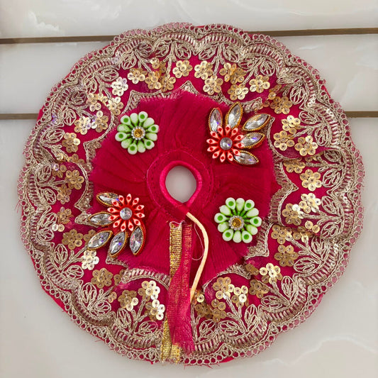 Decorative red circular piece with gold embroidery on a white background