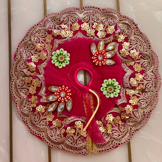 Decorative red circular piece with gold and green embellishments on a tiled wall background