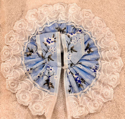 Blue floral patterned fabric with white lace on a beige background