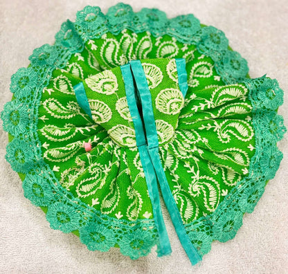 Green and turquoise decorative item with paisley patterns on a beige background