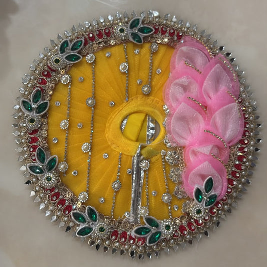 Handcrafted yellow and pink designer dress and matching crown for Ladoo Gopal Ji with floral and crystal embellishments.