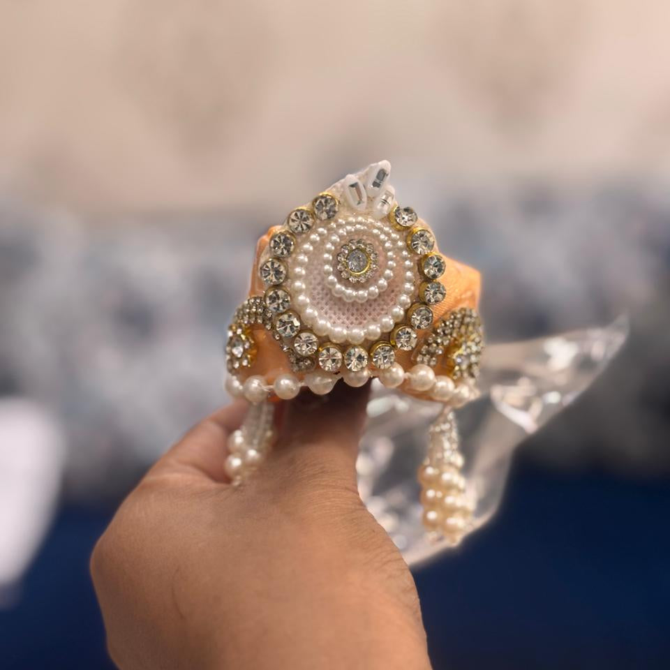 Bhavyaam Kesariya Rajputana handcrafted peach kesari Laddu Gopal Ji poshak with multicolor gota border, pearl crystal detailing and matching designer pearl Mukut for Janmashtami and Rajbhog seva.