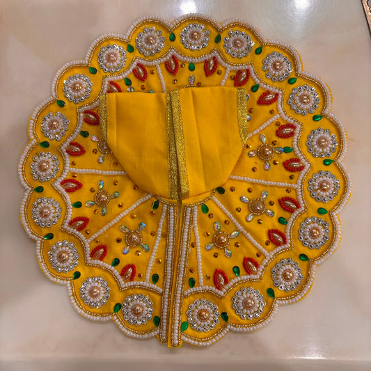 Bhavyaam Pitambar Vaibhav Poshak for Ladoo Gopal Ji featuring a handcrafted yellow designer dress with pearl embroidery, kundan embellishments, floral detailing, and a matching royal mukut.