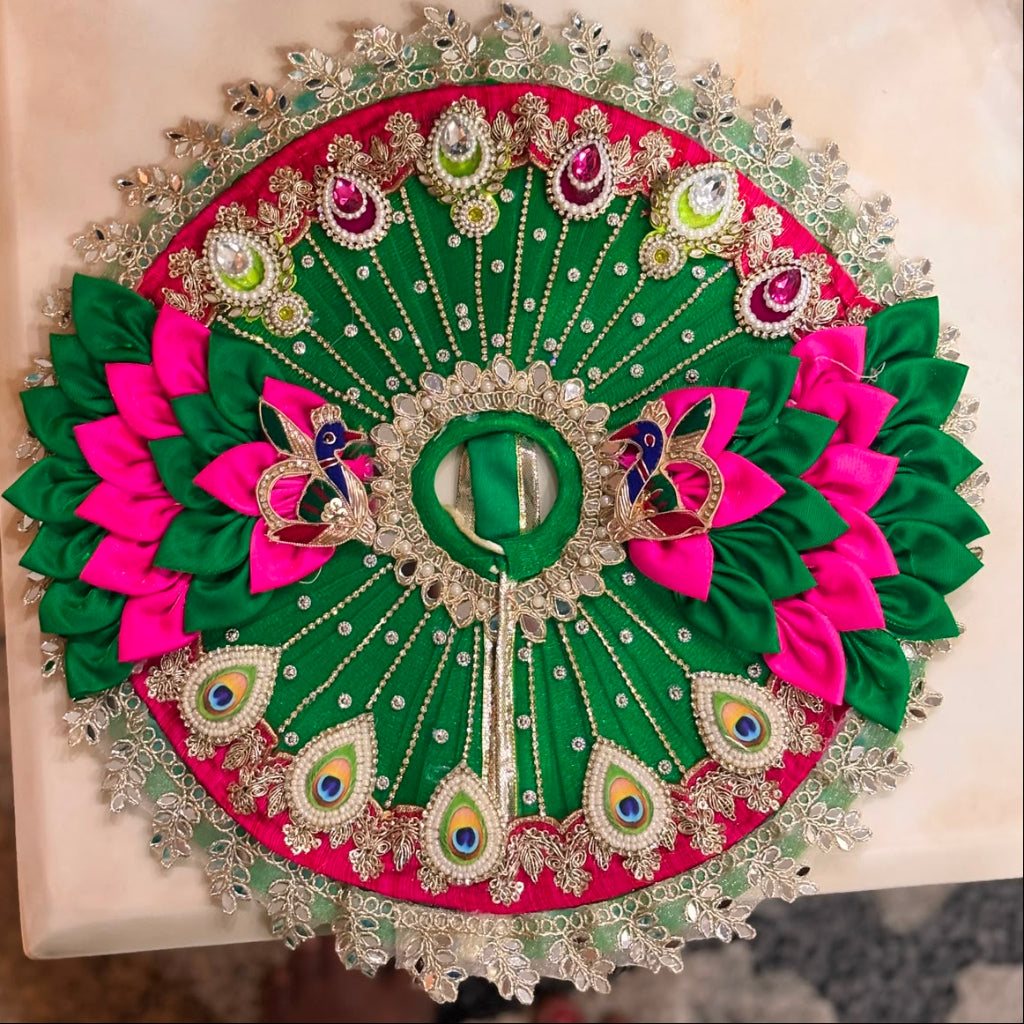 Handcrafted emerald green and pink Morpankh Rajsi Laddu Gopal Ji Poshak with designer Mukut featuring peacock feather embroidery, pearl work and premium Shringar by Bhavyaam.