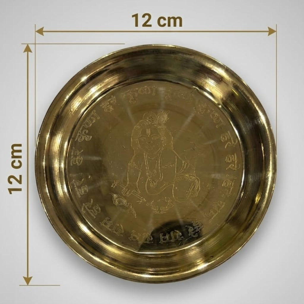 A polished brass Pooja Thali set including a plate, bowl, glass, and decorative spoon