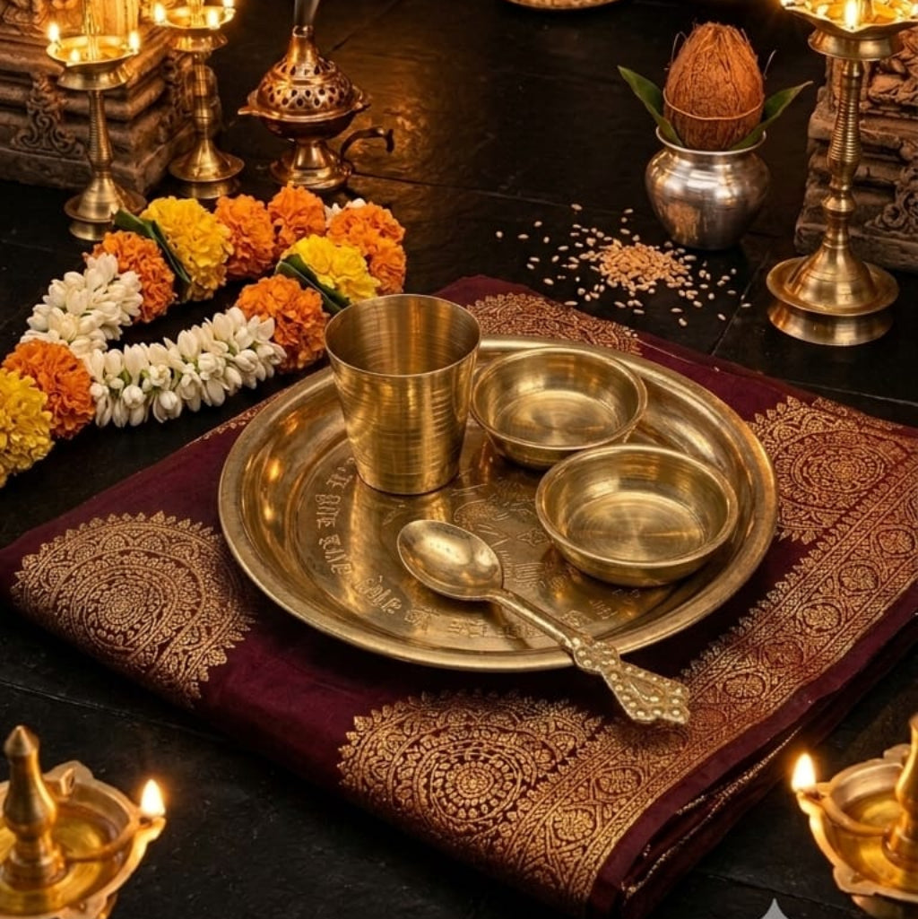 A polished brass Pooja Thali set including a plate, bowl, glass, and decorative spoon