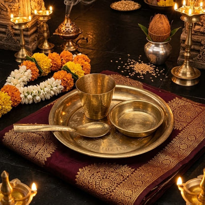 A polished brass Pooja Thali set including a plate, bowl, glass, and decorative spoon