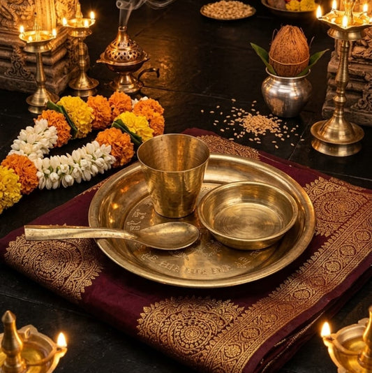 A polished brass Pooja Thali set including a plate, bowl, glass, and decorative spoon