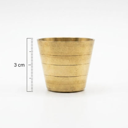 Brass cup with measurement scale on a white background