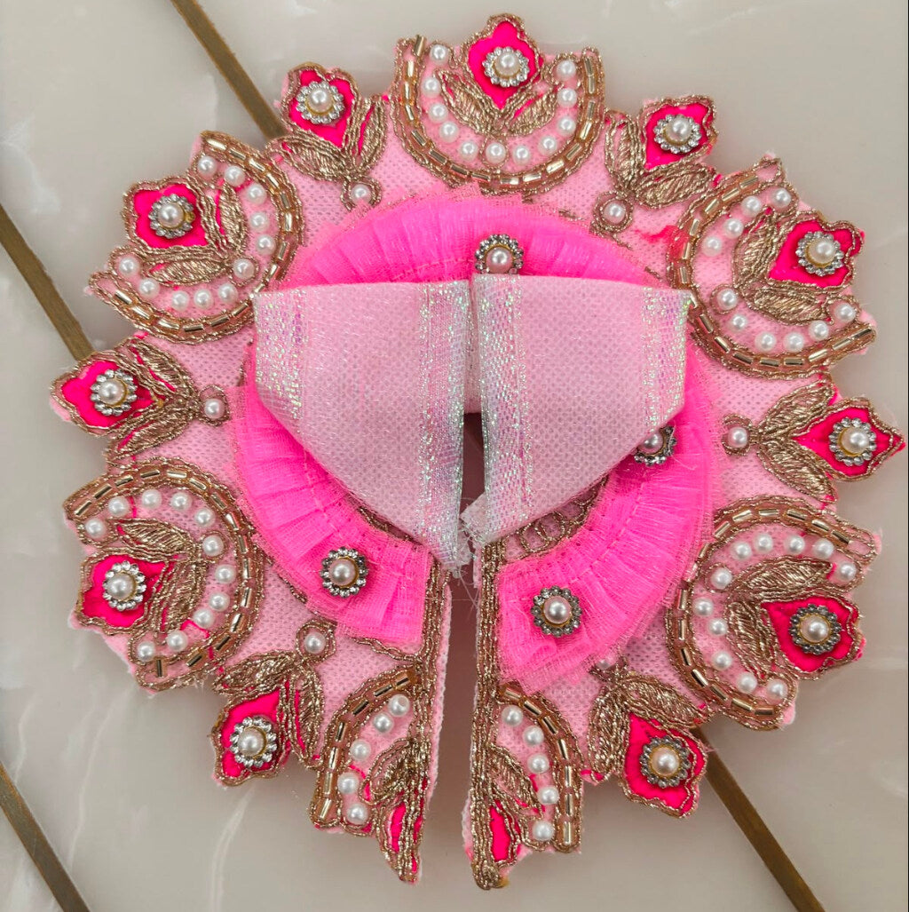 Decorative pink and gold garment with intricate patterns on a light background