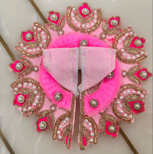 Decorative pink and gold garment with intricate patterns on a light background