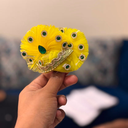 Handcrafted sunny yellow and emerald green designer dress and matching fan-shaped crown for Ladoo Gopal Ji, featuring pearl flowers and gemstones.