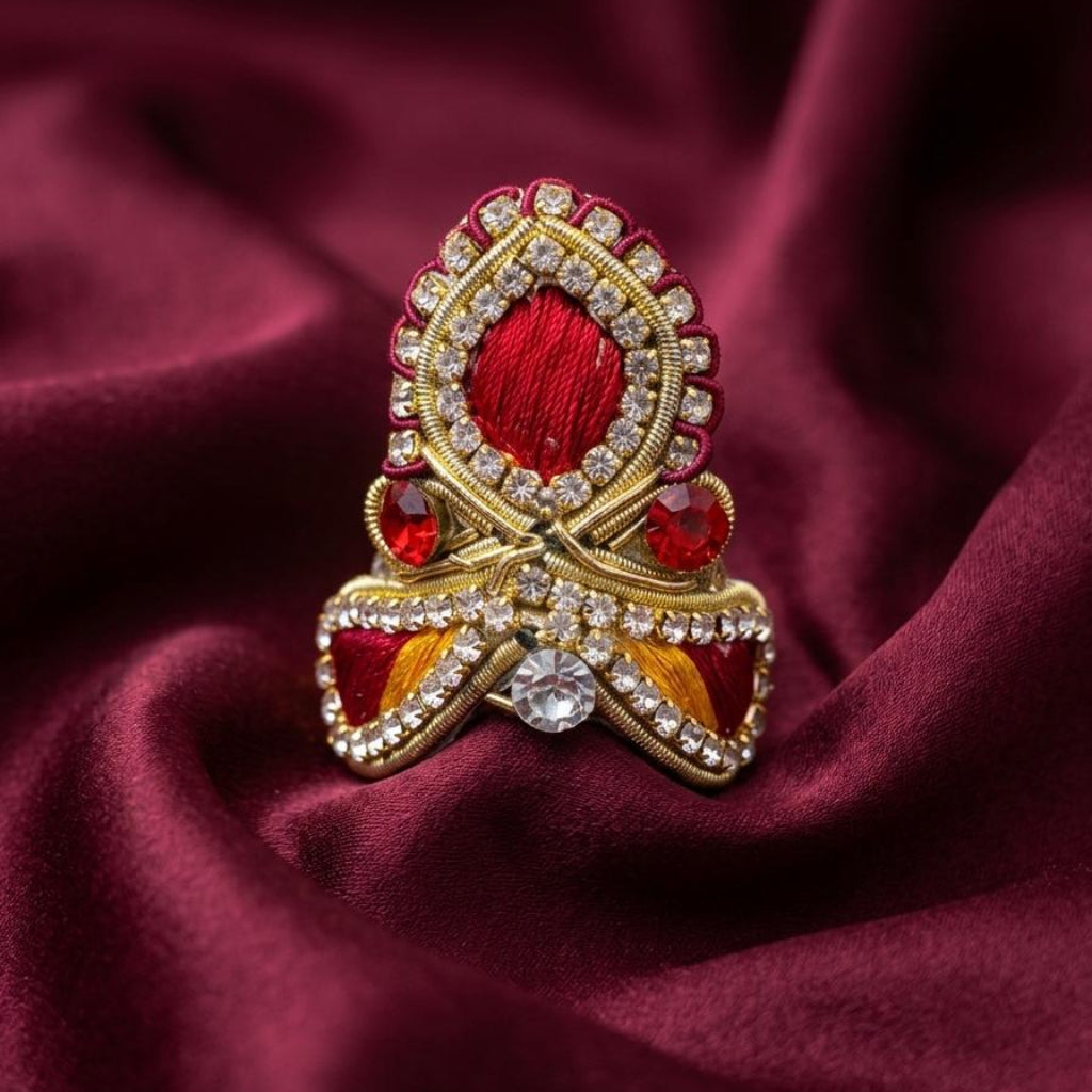 Ruby red designer mukut for Ladoo Gopal Ji featuring crystal embellishments and handcrafted golden detailing