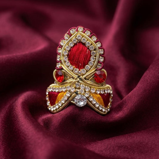 Ruby red designer mukut for Ladoo Gopal Ji featuring crystal embellishments and handcrafted golden detailing