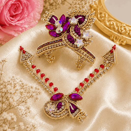 Ornate necklace with purple and red stones on a soft surface with flowers and a mirror in the background