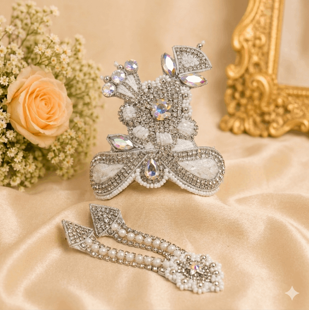 Decorative brooch with gemstones and pearls on a beige fabric background with flowers and a gold frame.