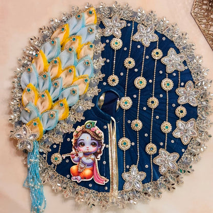 Handcrafted royal blue designer dress and matching crown for Ladoo Gopal Ji, featuring a deity appliqué, mirrors, and crystal star motifs.