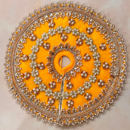 Handcrafted golden-yellow designer dress and matching crown for Ladoo Gopal Ji, adorned with pearl flowers and sparkling crystals.