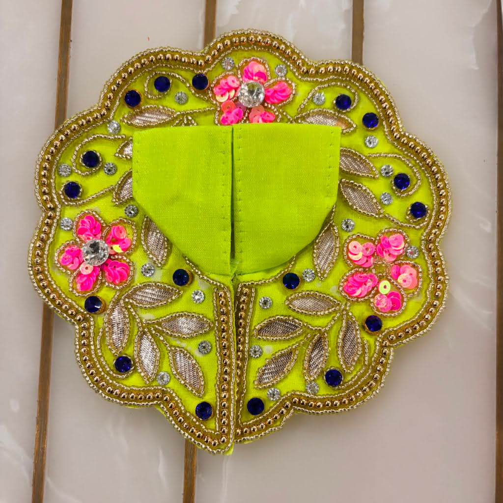 Decorative green patch with floral and leaf patterns on a white background
