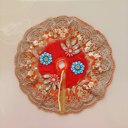 Decorative red fabric with gold embroidery and blue flowers on a white background