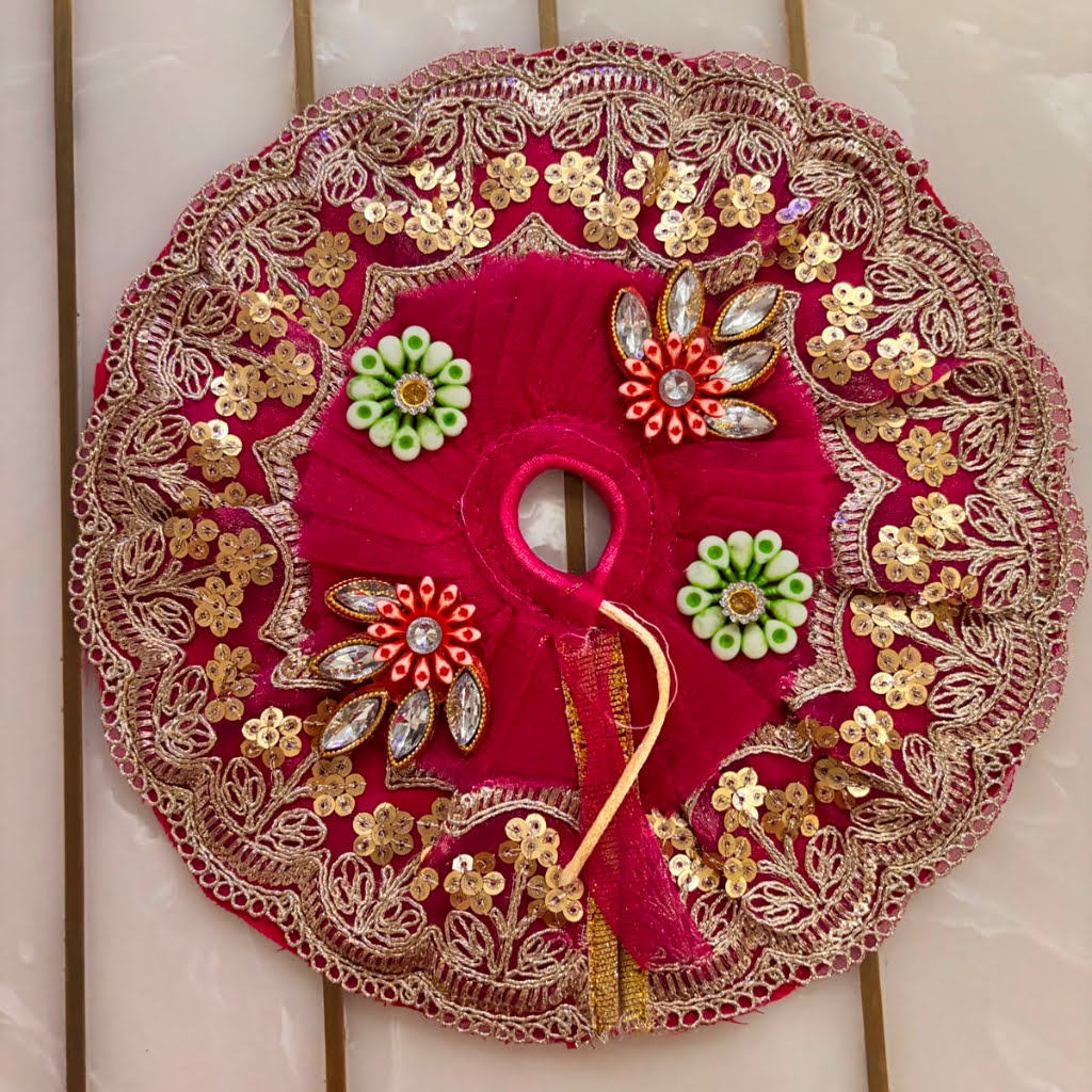 Decorative red circular piece with gold and green embellishments on a tiled wall background